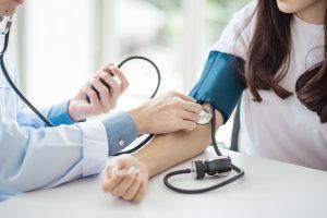 Doctor taking blood pressure of patient