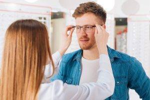 Optometrist fits glasses on a man